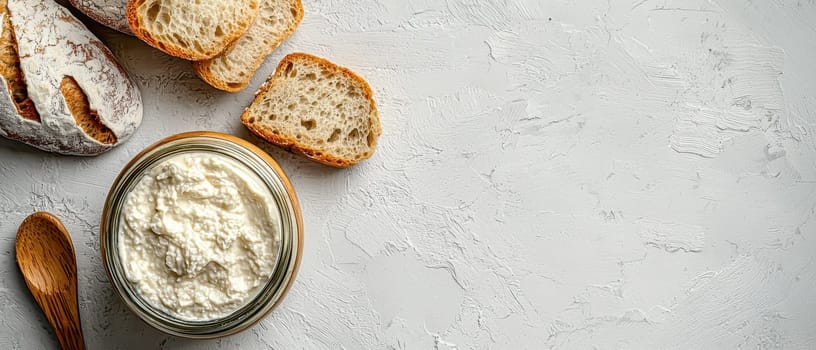 A jar of creamy fermented cottage cheese with slices of artisan sourdough bread on a textured background. A probiotic-rich dairy product for gut health and wellness. Space for text on the right.