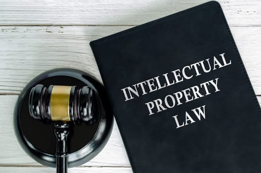 Top view of Intellectual Property Law book with gavel background.