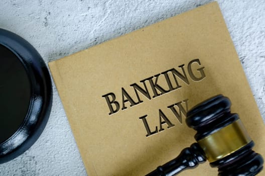 Top view of Banking Law book with gavel on marble background.