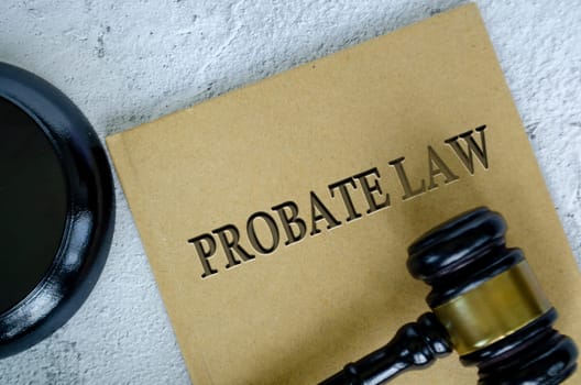 Top view of Probate Law book with gavel on marble background.