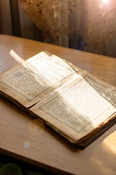Belarus, Minsk - 09.03.2025: An ancient book, filled with stories from long ago, lies open upon a wellworn wooden table, inviting readers to explore its pages