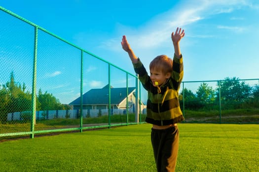 The child goes in for sports at the stadium. The boy training before playing football. High quality photo