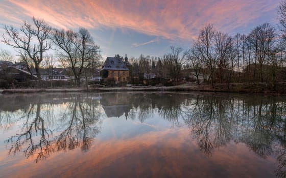 Bergisch Gladbach, Germany - December 27, 2024: Panoramic image of old castle Zweifel with water reflection during early morning on December 27, 2024 in Bergisch Gladbach, Germany