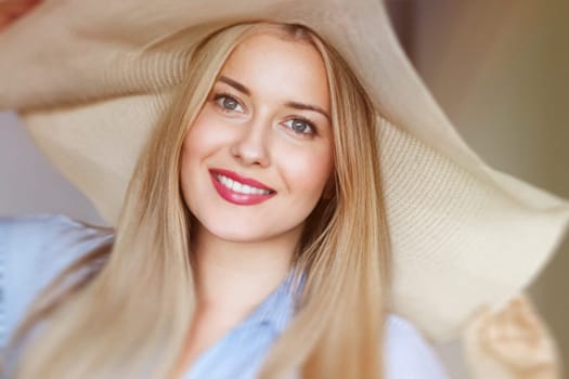 Woman, fashion and summer country charm, blonde beauty and elegance in wide brimmed beach hat. Feminine allure, timeless style and graceful glow. Smile, straw hat and blue striped blouse, natural lighting and effortless charm, fashion look idea
