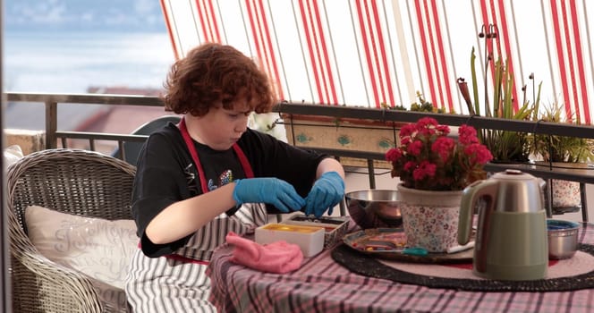 A young child focused on coloring Easter eggs using bright dyes and tools at a cozy outdoor table. The atmosphere is festive, perfect for decorating eggs.