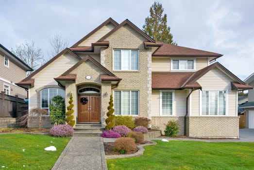 A perfect neighborhood. Nicely landscaped front yard of luxury residential house with paved pathway to the entrance. Luxury residential house