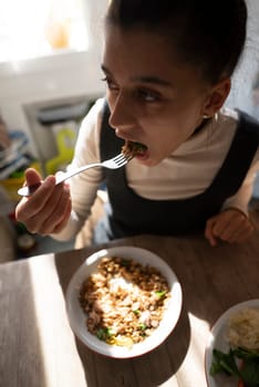 A woman savoring her delicious meal in a cozy indoor setting. Perfect for food and lifestyle themes.