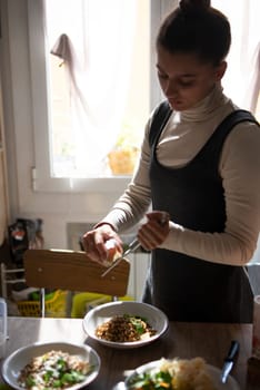 In a sunlit kitchen, a young woman plates a gourmet dish, showcasing her impressive culinary skills