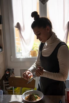 A woman skillfully prepares a delicious meal in a bright, stylish kitchen, showcasing her culinary talents