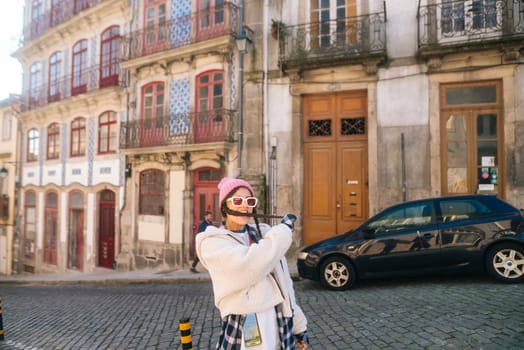 A fashionable individual poses confidently in a colorful urban landscape, showcasing style and charm.