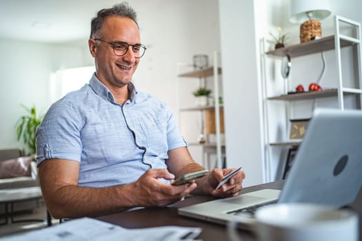 Middle aged Caucasian man online shopping at home.