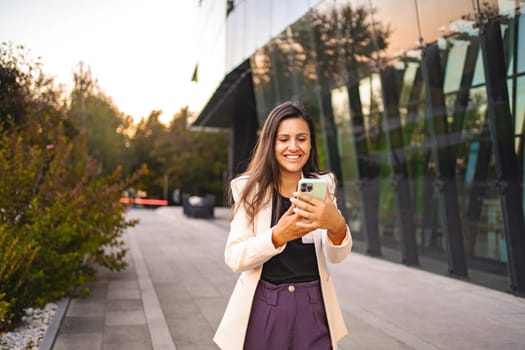 Excited businesswoman using mobile phone after work.