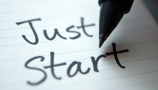 Just Start written in a notebook with a black pen on it