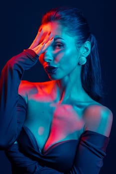 Bold studio portrait of confident woman in vibrant red-blue lighting, showcasing style, glamour, and attitude.