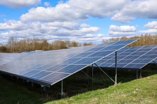Rows of solar panels capturing sunlight in a field, generating sustainable electricity under a cloudy sky