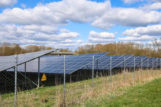 Photovoltaic panels generating electricity in a solar park, producing renewable energy under a cloudy sky