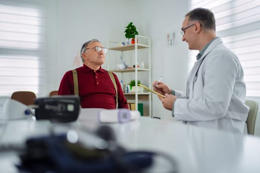 A healthcare professional engages with an older man during a checkup.