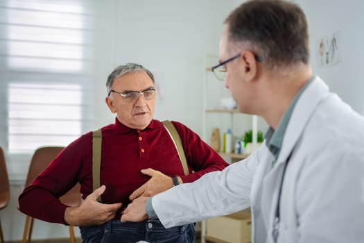 A doctor examines an elderly man in a modern medical office today.