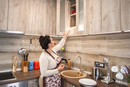 Woman organizing the kitchen cabinet.