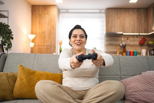 Woman having fun playing video games at home.