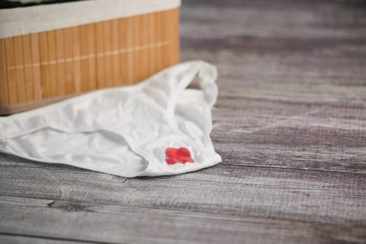 underwear with Red Stain on Rustic Wooden Surface.