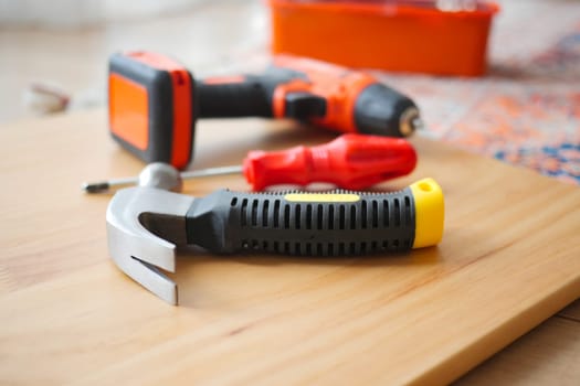 Various tools are arranged on a wooden surface for DIY projects.
