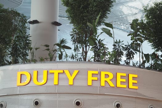 People browse through stores while enjoying greenery in the airport.