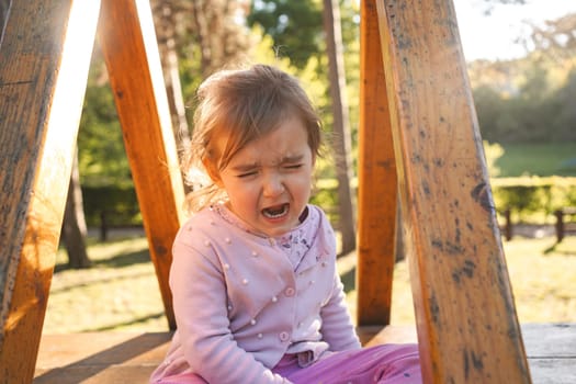 Little girl crying on the playground in the playground.