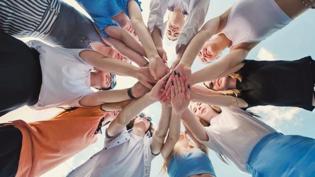 Group of school friends forming a circle, joining their hands together, symbolizing unity, teamwork, and collaboration