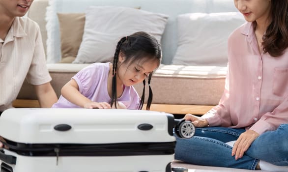 A family gathers at home to prepare for an upcoming trip, with a little girl excitedly inspecting a suitcase, reflecting moments of connection and adventure.
