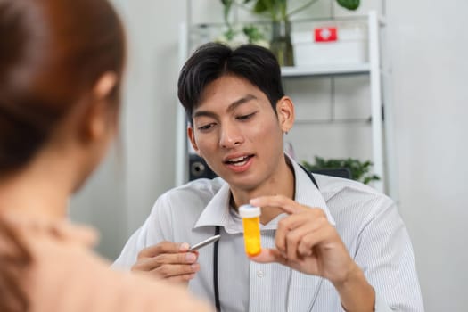 A doctor explains treatment options using a prescription bottle during an informative patient consultation.