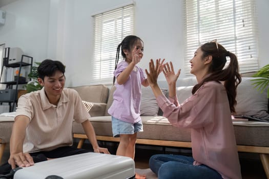 A delightful moment as a mother and father share a fun clapping game with their daughter, showcasing love, laughter, and precious family time.