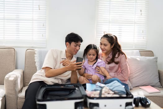 A family collaborates to pack a suitcase, teaching their daughter about organization and excitement for their next adventure together.