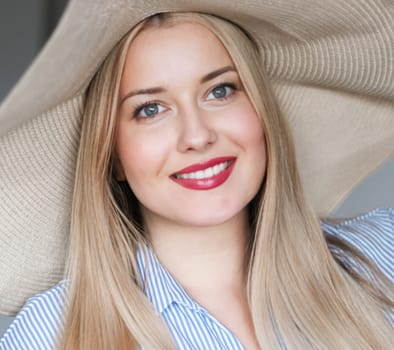 Woman, fashion and summer country charm, blonde beauty and elegance in wide brimmed beach hat. Feminine allure, timeless style and graceful glow. Smile, straw hat and blue striped blouse, natural lighting and effortless charm, fashion look idea