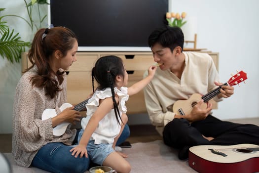A delightful scene where a little girl playfully engages with her parents during a musical session, highlighting joy and family connection.