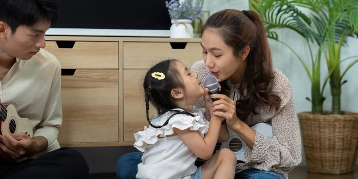 A heartwarming scene as a mother and daughter sing into a microphone, enjoying the music and creating lasting memories in their comfortable home setting.