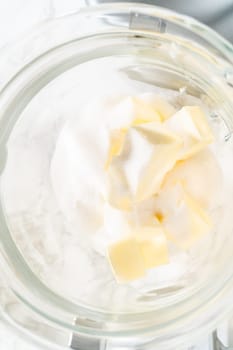Top view of sugar and butter cubes in a mixing bowl, ready to be creamed together as the first step in making Classic Sugar Cookie Dough. The ingredients are positioned for blending, a key step for creating a smooth cookie base.
