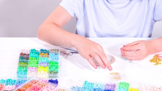 Delicate fingers of a young girl navigate through a treasure trove of bright, multicolored beads, each compartment revealing a new hue to choose from.