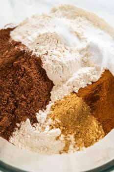 Close-up of a mixing bowl with cocoa powder, flour, ginger, and cinnamon for the Chocolate Ginger Sugar Cookie Dough, showing the spices and dry ingredients ready for mixing.
