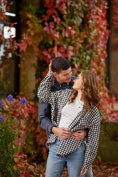 Young Cute Female Hugs Boyfriend. In Autumn Outdoor. Lovers Walking in Park. Attractive Funny Couple. Lovestory in Forest. Man and Woman. Cute Lovers in the Park. Family Concept. Happy Couple.