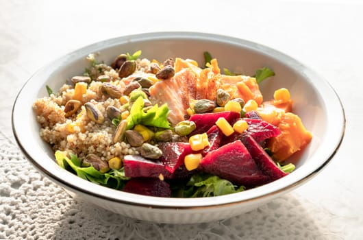 Delicious Quinoa Salmon Poke bowl garnished with Leaves salad, Beetroot, Sweet potato, Sweet corn and Pistachio on Ceramic bowl. use it as your Wallpaper, Poster, Design and Space for text, Selected focus.