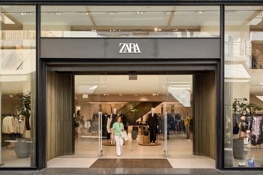 Crete, Greece - April 7, 2025: A modern Zara store with a sleek glass fa ade and minimalist design, showcasing mannequins dressed in trendy fashion in a bustling urban shopping area.