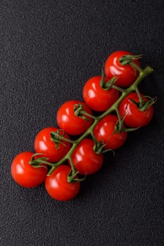 Red cherry tomatoes on a branch, a spiced vegetable as an ingredient for making sauces and ketchup