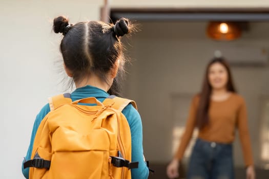 As the girl faces her mother with a delighted expression, the nurturing bond between them shines through, encapsulating the spirit of family encouragement before school.