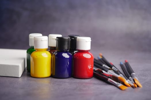 Colorful paint bottles and brushes arranged for a creative activity.