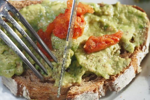 Delicious avocado spread on whole grain bread garnished with tomatoes
