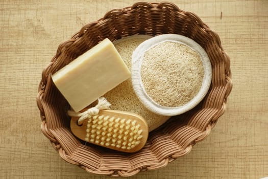 A basket filled with loofah, soap, and a scrubbing brush for bathing.