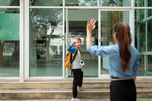 A young boy waves goodbye to his mother, filled with anticipation for the school day ahead. This heartwarming moment showcases the bond between them and the importance of family support.