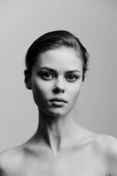 A striking black and white portrait of a young woman with captivating features, conveying strength and introspection, emphasizing natural beauty and elegance.