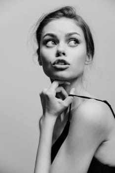 Pensive female model with soft features and a natural look, captured in a black and white portrait, embodying beauty and reflection.